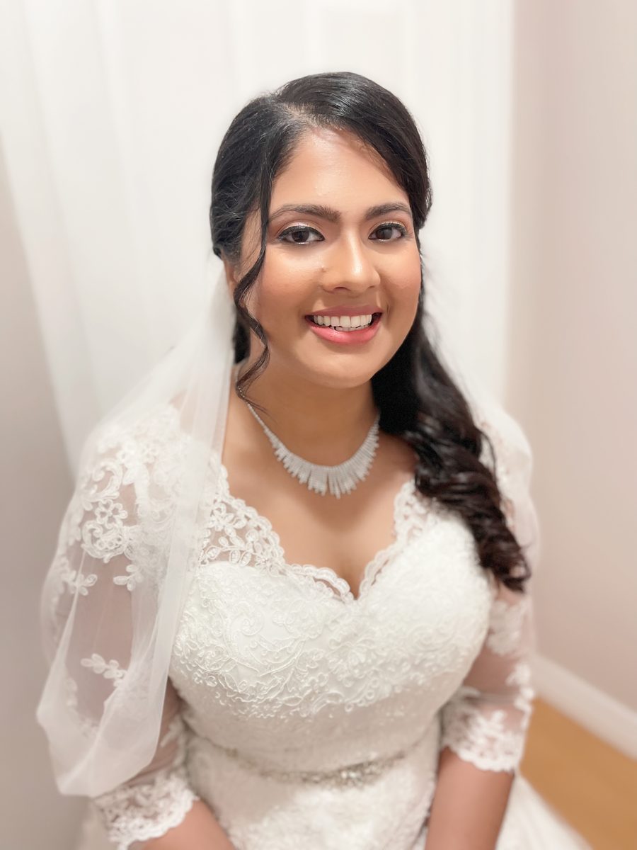 Bride with soft glam makeup and side-swept curls
